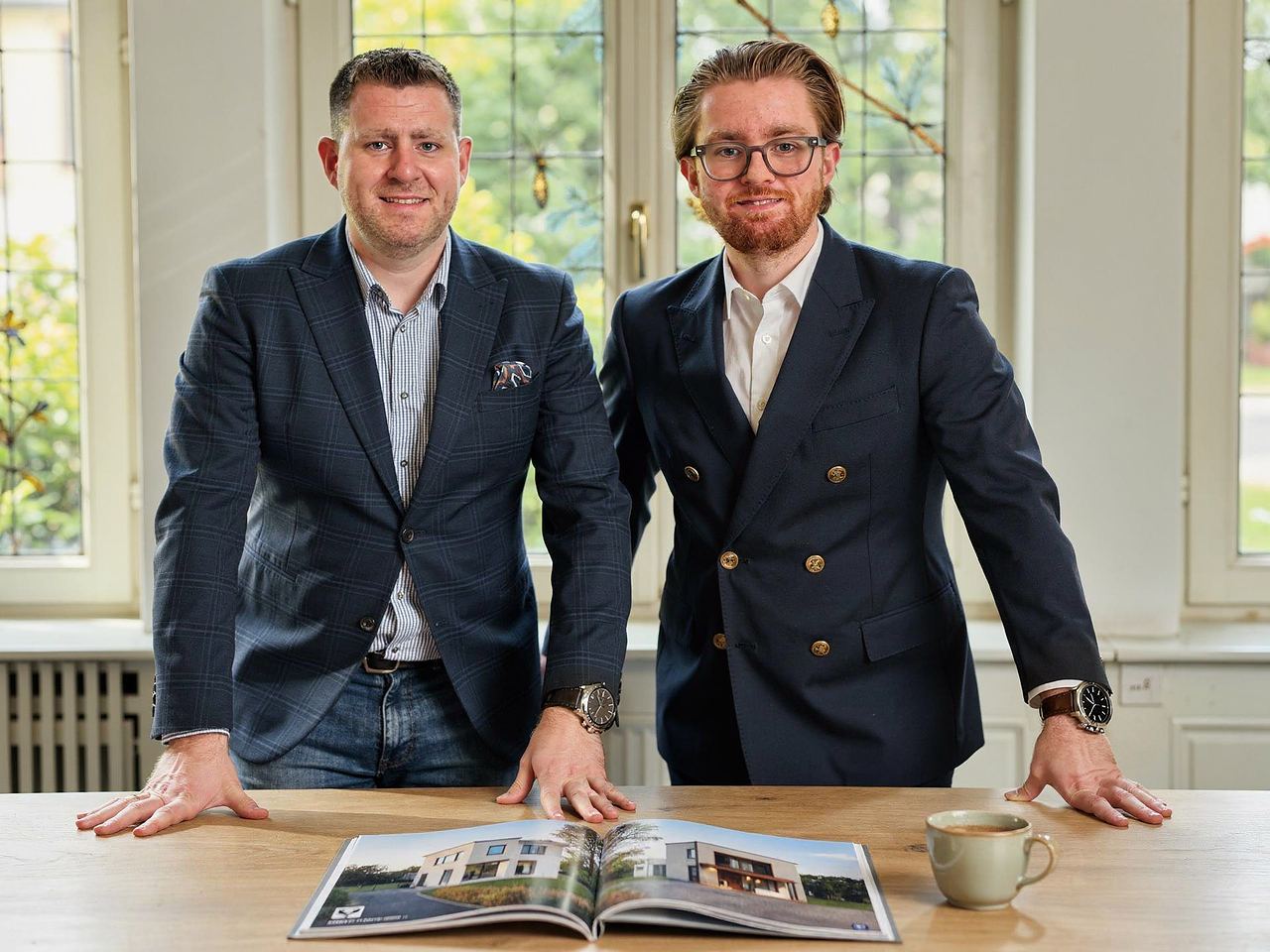 Jöran C. Bayer und Finn C. M. Bayer am Tisch mit einem aufgeschlagenen Exposé
